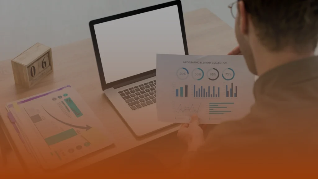Whissel Strategies A person reviews data charts in front of an open laptop on a desk with documents and a wooden calendar block displaying "06". Toronto Digital Marketing Agency