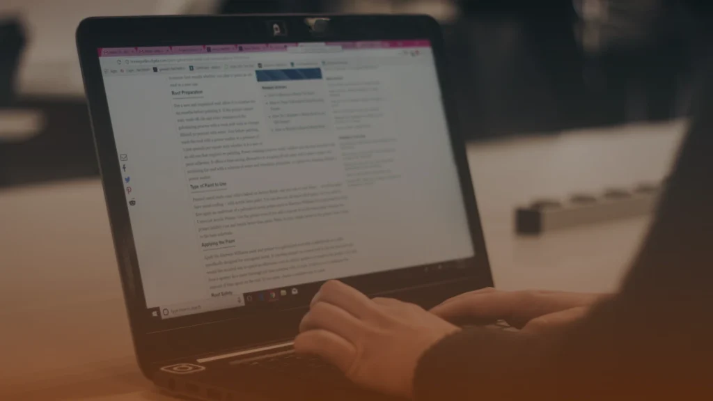 Whissel Strategies Person typing on a laptop with a website or document displayed on the screen in a dimly lit indoor setting. Toronto Digital Marketing Agency