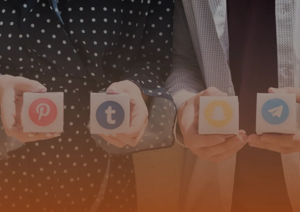Whissel Strategies Four hands hold cubes displaying the logos of Pinterest, Tumblr, Snapchat, and Telegram. The background is neutral, and the people are dressed in patterned and textured clothing. Toronto Digital Marketing Agency